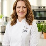 Sophie Bennett in a white chef-style jacket in a bright kitchen