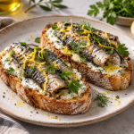 Crisp artisan toast topped with sardines, lemon zest, fresh herbs and creamy spread