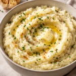 Creamy roasted garlic mashed potatoes with melted butter and chives